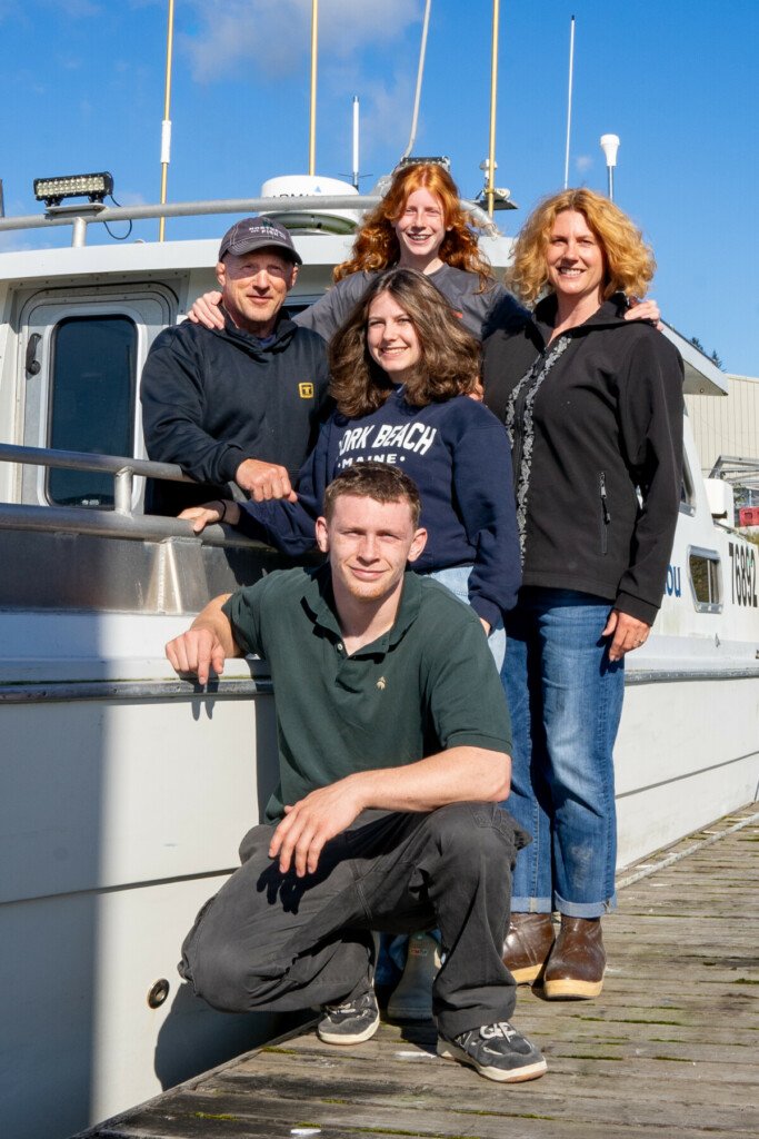 Sena Wheeler and her commercial fishing Family near a fishing boat