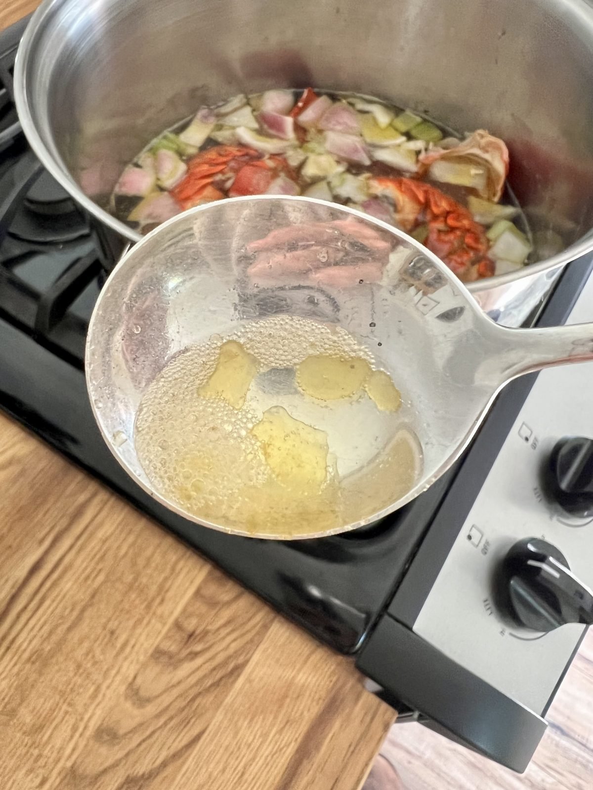 Lobster stock bubbles in spoon