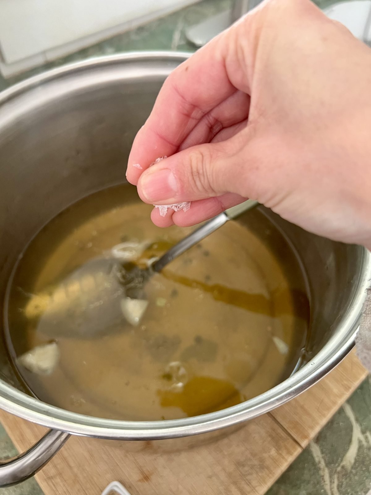 adding sea salt to homemade lobster stock