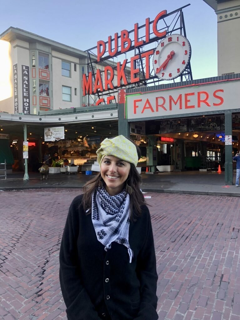 woman in fashion turban and scarf in front of Seattle Public Market